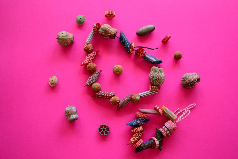 Homemade jewellery from decorated plants and pasta on a pink background