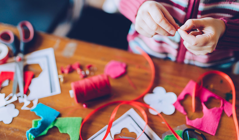 Girl sewing felt decorations