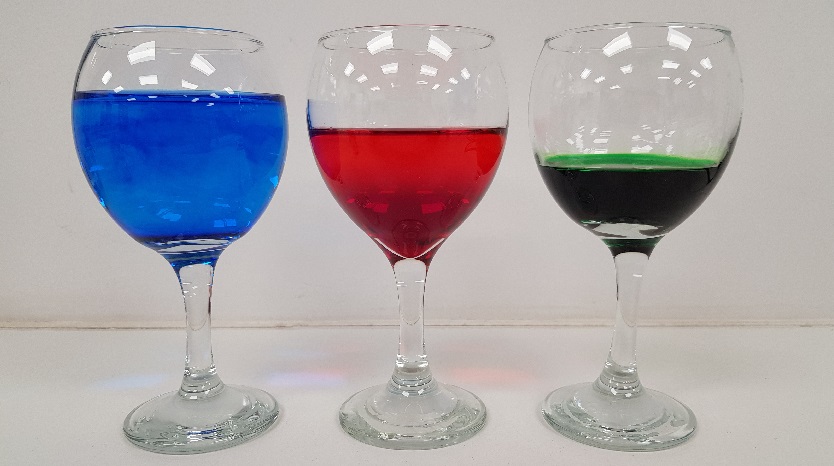 3 Wine Glasses eatch containg blue, red and green coloured water at different levels