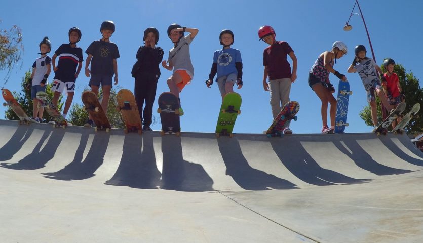 Group of preteen boys on skateboards.