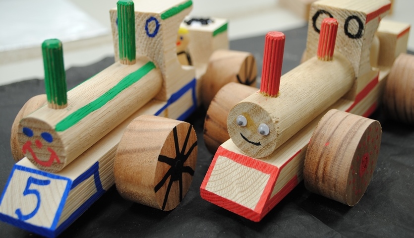 Two toy trains made of different shaped wooden blocks.