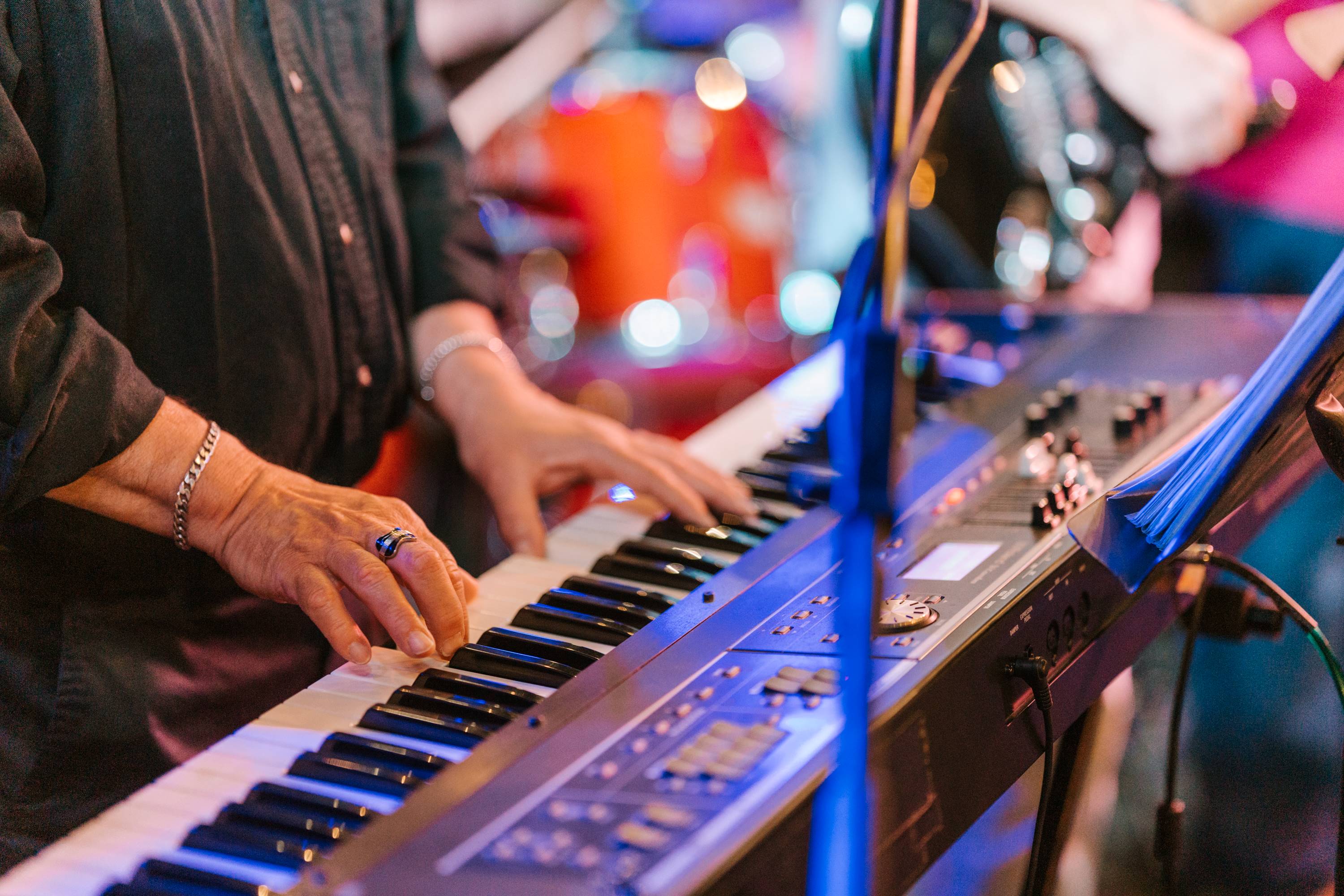 Hands playing an electric keyboard at a music performance