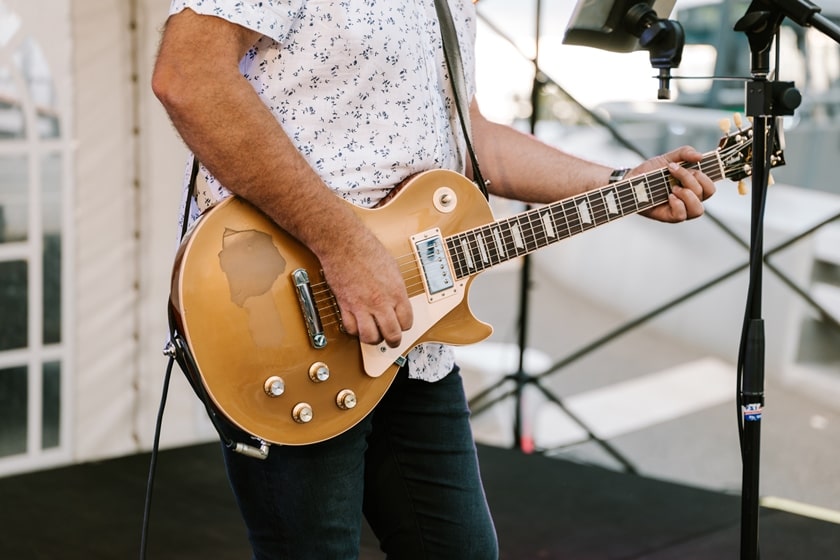 Male musician playing an acoustic guitar close up.