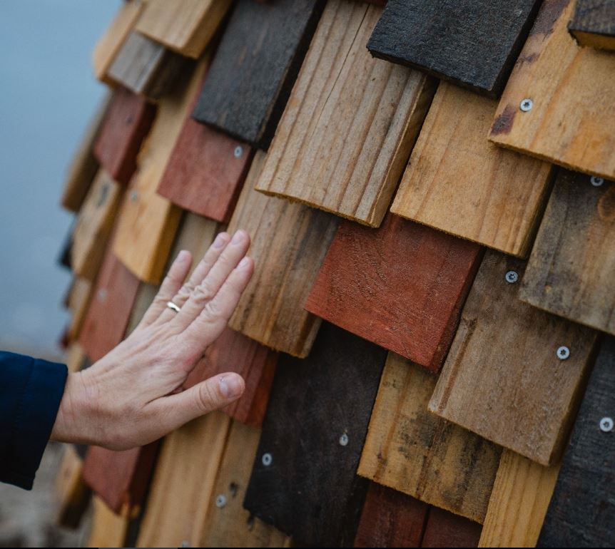 Hand touching wood of Giant of Mandurah sculpture