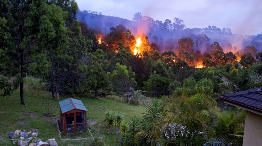 House slash shed in foreground with bushfire in background
