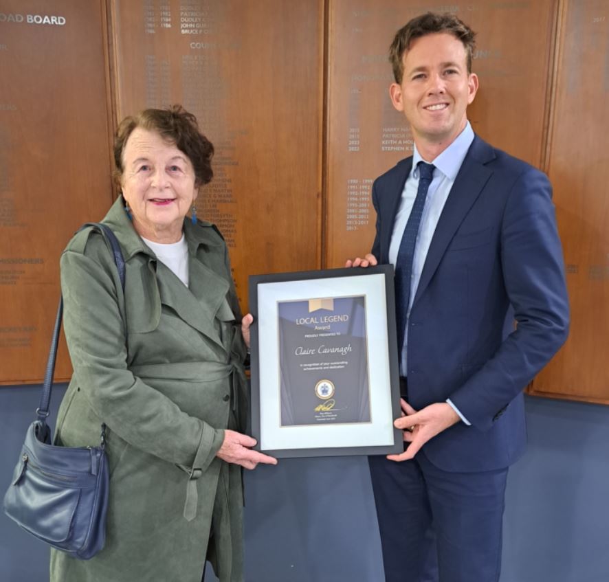 Claire Cavanagh and Mayor Rhys Williams stand side by side holding Local Legend award
