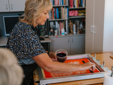 Woman screen printing onto a canvas 