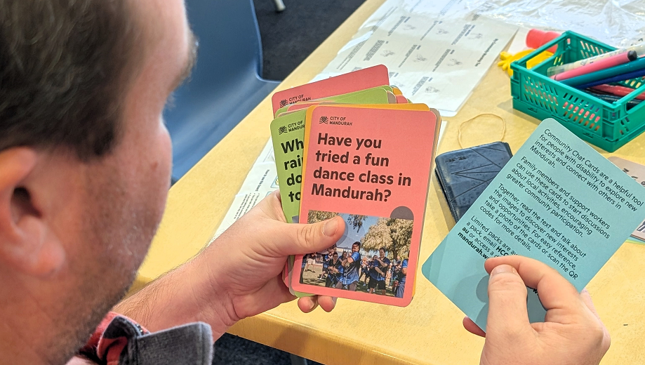 Gentleman holding My Community Chat Cards and looking through them.