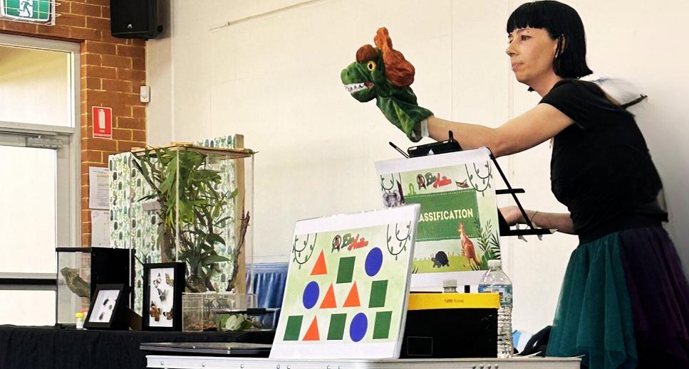 Eco Action staff member performing puppet show for children.