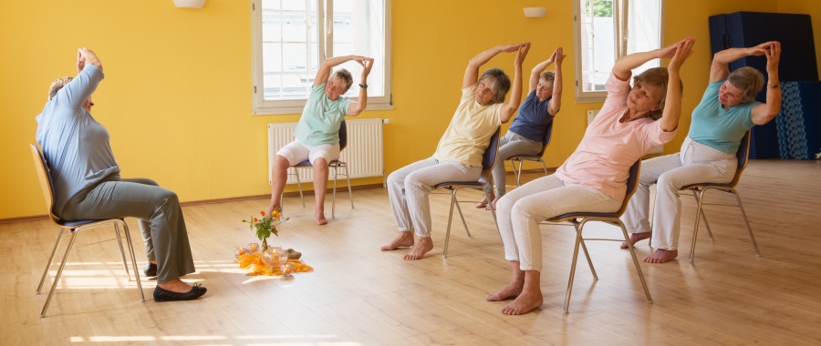 Seniors performing chair yoga