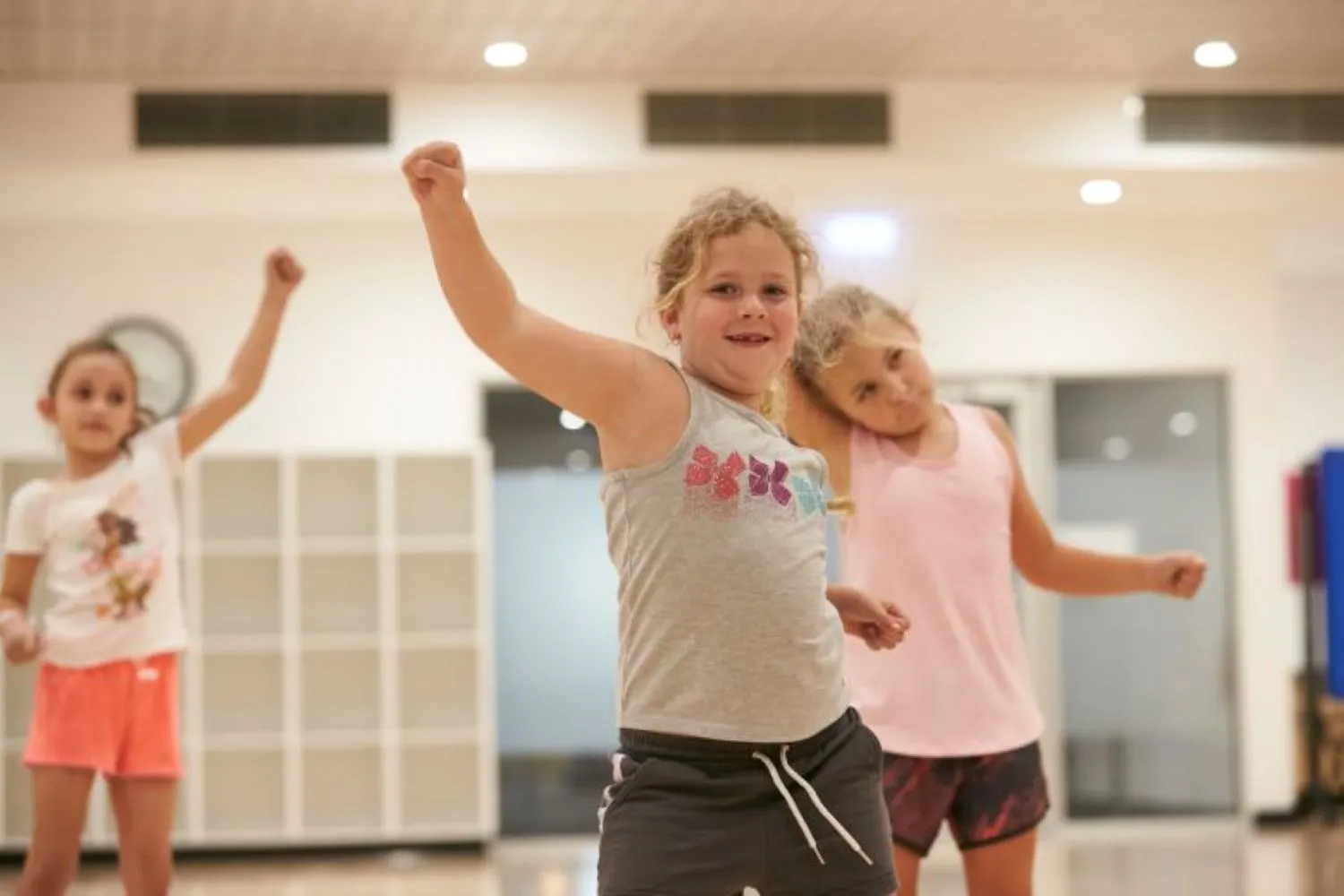 Young girls in DanceFit Class with arms in the air.