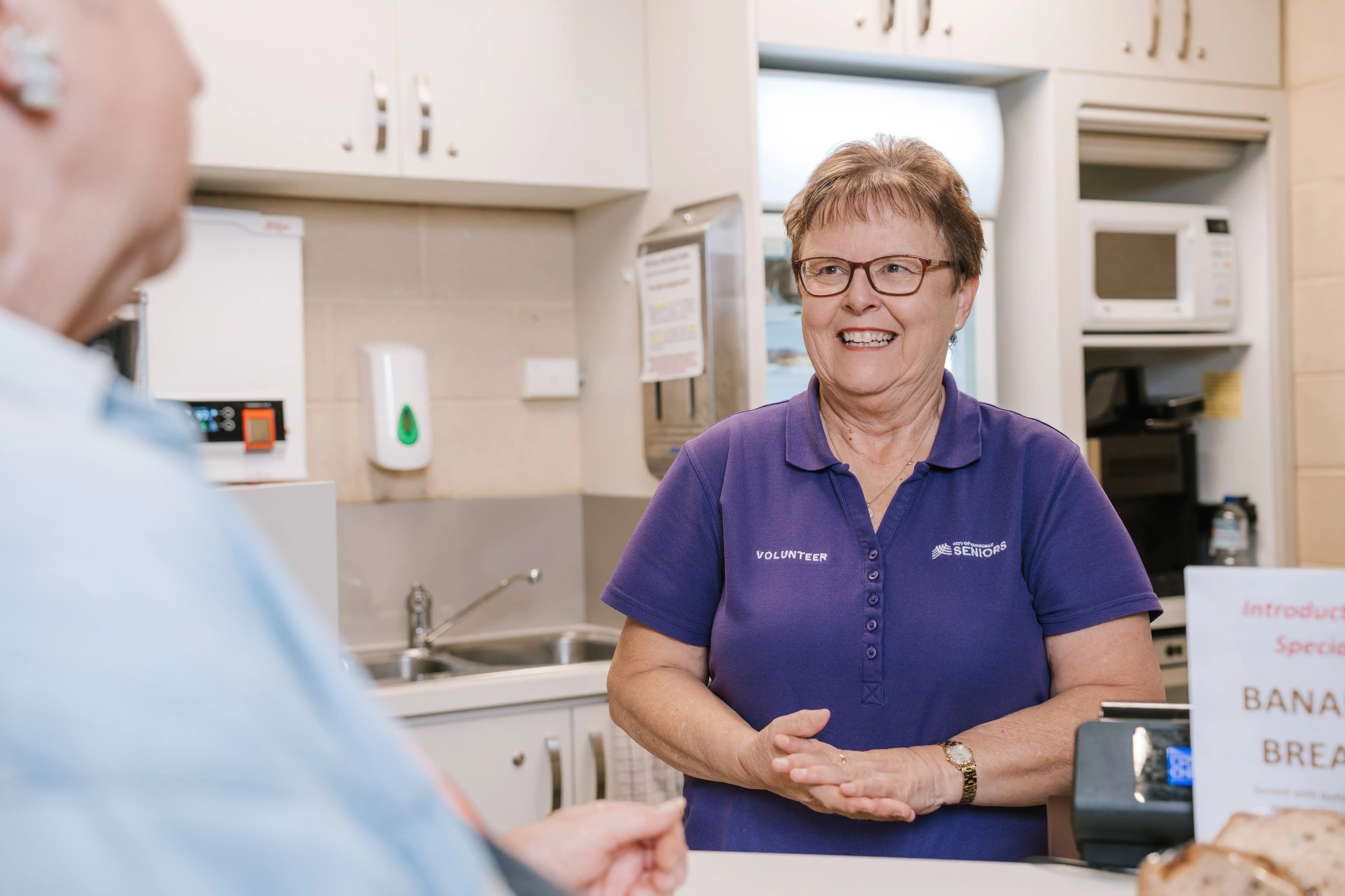 Seniors staff member serving customer.