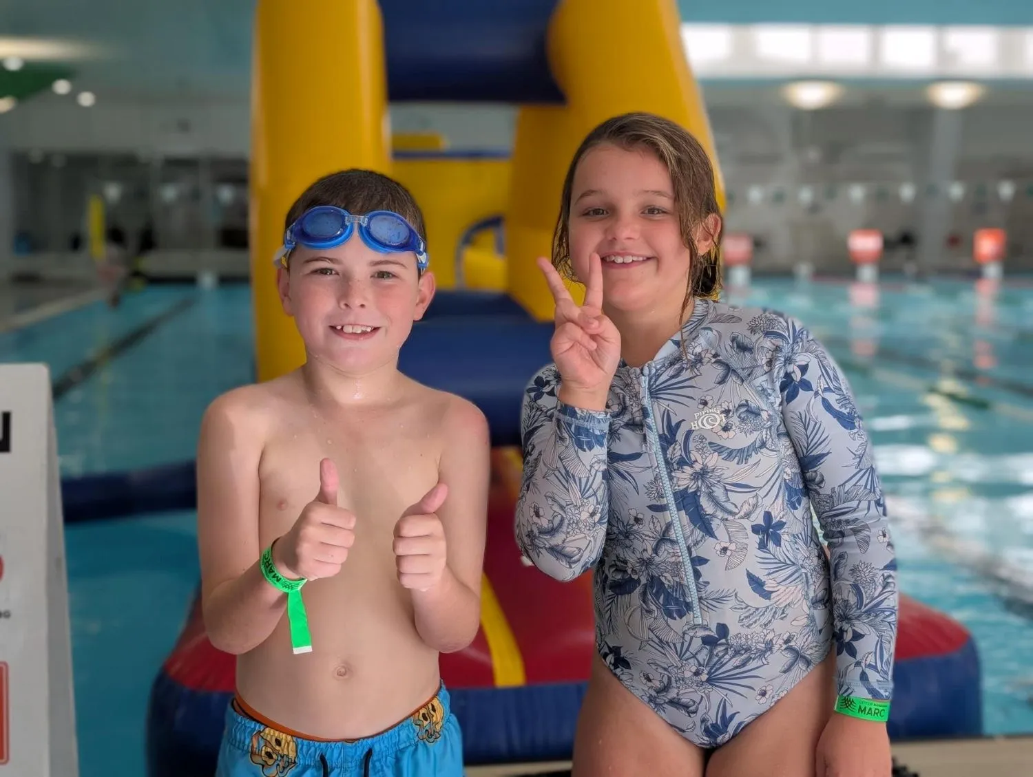 Two children standing in front of an inflatable floating obstacle course at the MARC