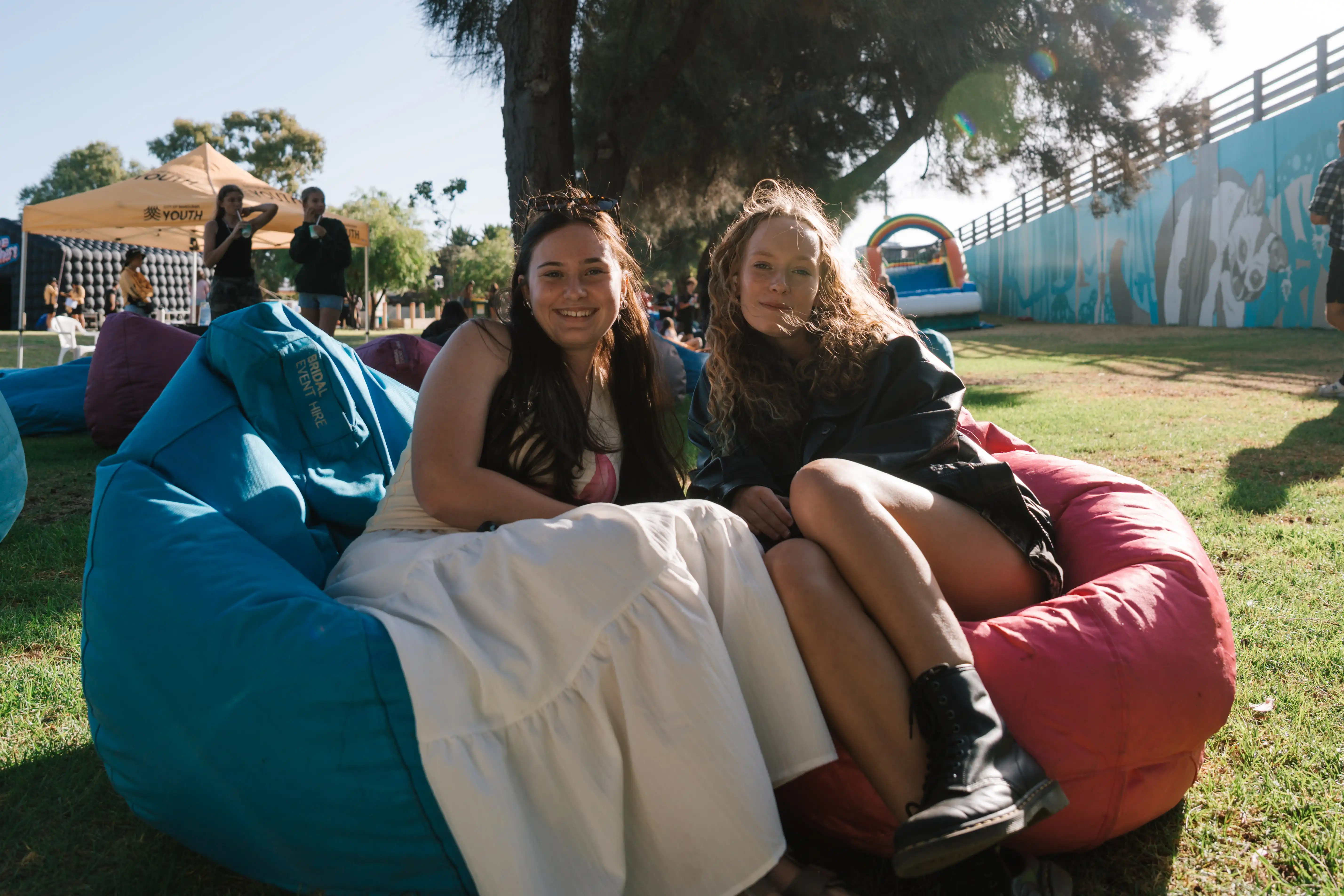 Two young people on bean bags at event.