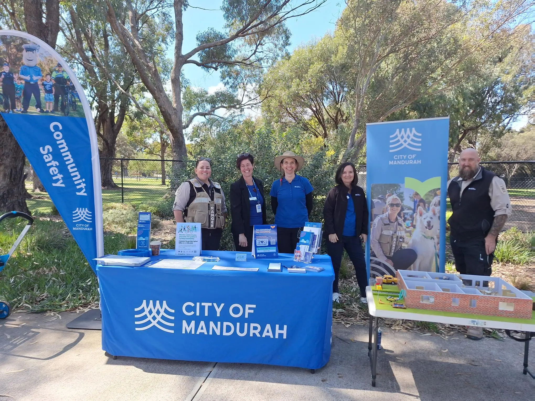City of Mandurah community safety staff and Rangers standing behind a City branded table with signage around them